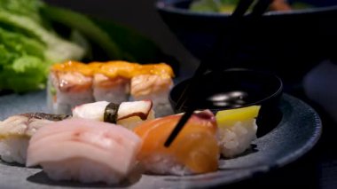 Uçan suşi parçaları yemek çubuklarının arasına yerleştirilir. Soya soslu suşi ve rulo havalanma. - Evet. Yüksek kalite 4k görüntü