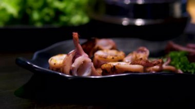 Kızarmış ahtapot tabağı, patates kızartması, limon, marul ve mavi masa örtüsünde garnitür, statik çekim. Yüksek kalite 4k görüntü