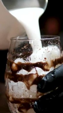 Slow Motion 'ın Kapanışı Çikolatalı Süt İçeceğini Tumbler Bardağına, Beyaz Fonda Barista' nın üzerine dök Bir bardak buzlu kahveye süt dök. Yüksek kalite 4k görüntü
