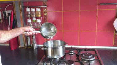 Pasta kabuğunu ıslatmak için şeker şurubu hazırlıyorum. Profesyonel şef su dolduruyor. Yüksek kalite 4k görüntü