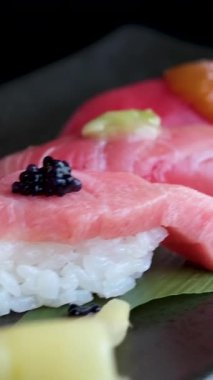 Bir tabakta çeşitli suşi ve deniz ürünleri sergileniyor. Yüksek kalite 4k görüntü