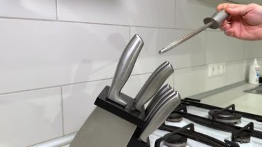 Bıçakları keskinleştiren biri. Adamın biri mutfaktaki bıçak keskinleştiricisini bıçak tezgahından çıkarmış.