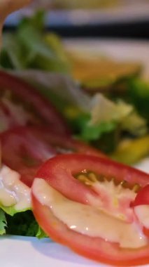 Şişeden zeytin yağı serpilmiş salata, bir kase taze Yunan salatası üzerine mayonez dökülmüş krema sosu.