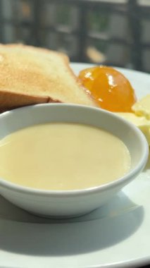 Yoğunlaştırılmış sütlü tost usulü kızarmış ekmek, fıstık ezmesi, tereyağı ve yoğunlaştırılmış süt ile birlikte bir restoranda yemeye hazır. Yüksek kalite 4k görüntü