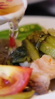 Lezzetli Asya eriştesi. Bir kase Asya eriştesi. Bu lezzetli tava yemeği taze soğan, kızarmış soğan ve susam tohumlarıyla süslenmiştir. balık sosu kırmızı biber yemeğin üzerine dökülür.