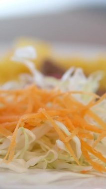 Şef şu malzemeleri kullanarak shawarma hazırlıyor: lavaş, et, sos, sebze, salatalık, soğan, lahana, baharatlı biber, patates, yeşillik, havuç. Yüksek kalite 4k görüntü