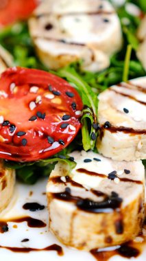 Domatesli, mozarellalı ve balzamik soslu tavuk caprese salatası yemek. Yüksek kalite 4k görüntü