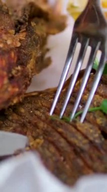 Tavada kızartılmış balık. Video, tavada kızartılmış balık pişirme sürecini gösteriyor. Altın, çıtır balık parçaları yağda kızarırken bir çatal da sulu bir parçayı koparır. Şişko olan. Yüksek kalite 4k 