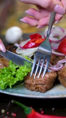 Şefin elleri hazırlama masasında biftek kesiyor, yakın plan. Aşçı eti bir tepside, levhada, doğal taştan yapılmış ızgarada keser. Yüksek kalite 4k