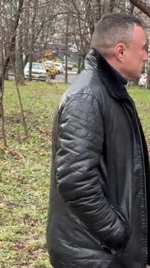 Sonbahar parkında deri ceketli bir adam. Yüksek kalite 4k görüntü