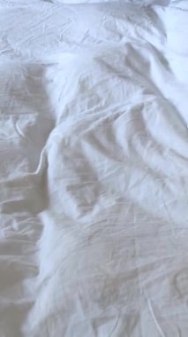 Genç İspanyol iş adamı otel odasında ceket giyerek yatağı yapıyor. Yüksek kalite 4k görüntü