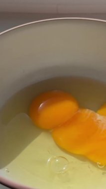 Ev yapımı omlet hazırlayan kadın çırpılmış yumurta ile karıştırıyor. Çırpılmış yumurta çırpıyorum. Çırpılmış yumurta omleti yapma süreci.