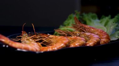 Asya yemek çubuklarıyla ızgara karides, kıvırcık marul ızgara balık ve karides. Yüksek kalite 4k görüntü