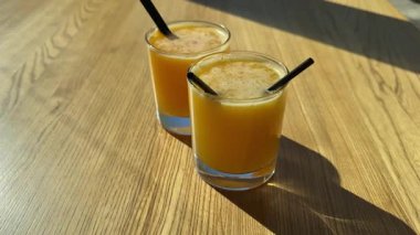 iki bardak portakal suyu ya da portakal kokteyli ya da cam bir kompozisyonda kesilmiş portakal ve yapraklarla içilir. Yüksek kalite 4k görüntü