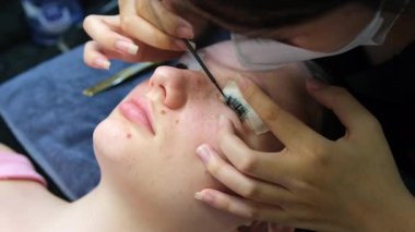 Kirpik uzatma süreci, deneyimli sanatçının şaşaalı bakışlarıyla bireysel kirpikleri hassas bir şekilde uygulamayı içerir. Profesyonel, hassas uygulama gelişmiş göz güzelliği.