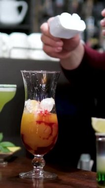 Profesyonel erkek barmen lüks gece kulübündeki müşteri barına kokteyl servisi yapıyor. Barmen Vinnytsia, Ukrayna bayramını kutlamak için karışık alkollü içecek hazırlıyor.