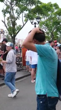 Hoi 'nin Riverside Mahallesi. Japon köprü arabaları ile Vietnam. Sokaklarda turistler geziyor, yerel kafeleri keşfediyor ve otantik kültürel yaşam tarzının tadını çıkarıyor.