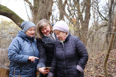 Üç yetişkin emekli kadın gölün kenarında huzur içinde vakit geçiriyorlar. Birbirlerine sarılıyorlar ve gün batımında samimi bir bağ kuruyorlar. Yüksek kalite fotoğraf