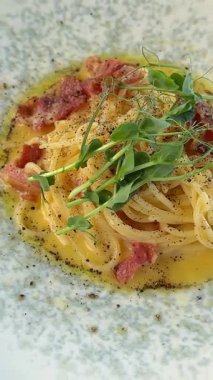 İtalyan mutfağı. Çıtır pastırmayla süslenmiş nefis ev yapımı spagetti. Klasik İtalyan makarnası, kremsi dokularla sunulur. Zengin zevkli İtalyan ev yapımı makarna yemeği.