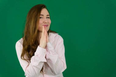 Zarif balıkçı yaka kazak giyen kızıl saçlı kadın izole edilmiş beyaz arka planda durup ellerini birleştirip af diliyor kendinden emin bir şekilde gülümsüyor. Yüksek kalite fotoğraf