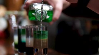 Profesyonel barmen, gece kulübünde misafirler için kokteyl sallıyor. Yüksek kalite 4k görüntü