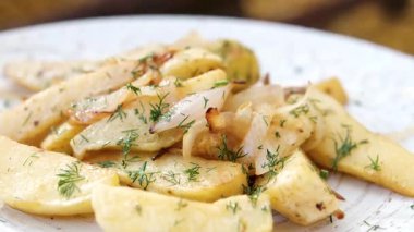 Mantarlı kızarmış patates, soğan, et, tabakta turşu. Arka planda bulanık insanlar. Yüksek kalite 4k görüntü