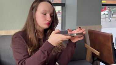 Açık havada akıllı telefon kullanan, telefonu tutan, cep telefonuyla yürüyen bir kadın. Yüksek kalite 4K görüntü. Yüksek kalite 4k görüntü