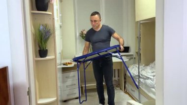 Bir adam çocuk odasında bir masayı açıyor. Katlama masası