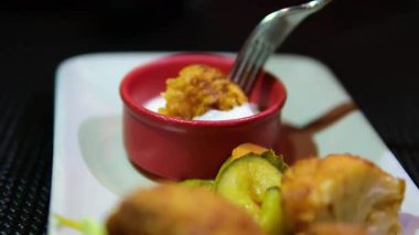 Abur cubur reklamı konsepti. Fast food teslimatı, kanepede oturup televizyon izlemek, arkadaşının tavuğunu elinde tutmak, koklamak ve ısırmak, tadını çıkarmak. Ağır çekim. Yüksek kalite 4k görüntü