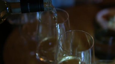 Garson elinde şampanya bardaklarıyla tepsi tutuyor. Garson restoranda insanlara servis yapıyor. Şarap kadehlerinde alkol içilir. Gece partisi, dışarıda tatil etkinliği. İnsanlar.