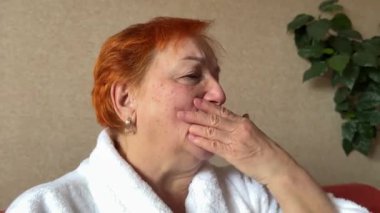 Sağlık laboratuarında bronşitlerle savaşırken öksürük, soğuk algınlığı belirtilerini ortaya çıkarır. Bornozlu bir kadın öksürüyor. Yaşlı bir kadın..