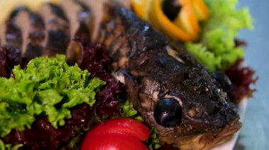 Limon ve otlarla dolu bir tahtanın üzerinde duran altın hamurlu fırında balık. Yüksek kalite 4k görüntü