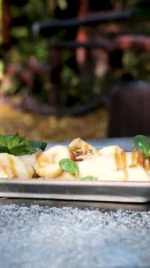 Orman restoranının sokaklarına düşerken üzerine toz şeker serpiştirilmiş muz serpiştirilmiş ince krepler taze böğürtlen ve pudra şekerli tatlı Fransız tostu. Yüksek kalite 4k görüntü