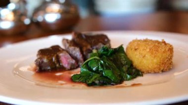 Ispanaklı et, kuzu budu, sos ve ratatouille. Lezzetli et kapanıyor. Yüksek kalite 4k görüntü