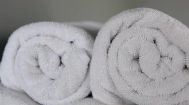 Sarılmış beyaz spa havluları rahatlamayı ve hijyeni simgeler. Ferahlatıcı bir banyodan sonra temiz ve lüks havlularla rahatlatıcı bir deneyimin tadını çıkar. Konukseverlik ve kişisel bakım için mükemmel..