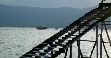 Balık çiftliğinin güzel doğal manzarası. Turistik yerler. Balık çiftliği ahşap köprüsü okyanus Vietnam evi suyun üzerinde. Yüksek kaliteli FullHD görüntüler