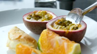 Her şeyi kapsayan bir kahvaltı restoranında beyaz tabakta tutkulu meyveli mandalina tatlısı. Yüksek kalite 4k görüntü