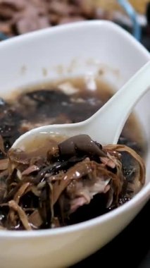 Bir kaseye bambu çorbası dökün, shiitake mantarları, ahşap mantarlar, kurutulmuş bambu Asya Vietnam mutfağı kızarmış börekler, kanatlar, bir sürü yeşillik, ıspanak, yengeç çubukları.