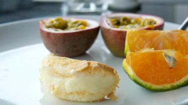 Her şeyi kapsayan bir kahvaltı restoranında beyaz tabakta tutkulu meyveli mandalina tatlısı. Yüksek kalite 4k görüntü