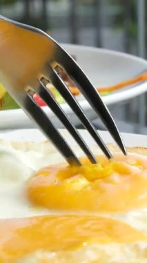 Sıcak bir kafeteryada yumurta salatasıyla nefis bir brunch 'ın tadını çıkaran cıvık sarısı bir kadınla yumurta keserek yemek ve ambiyans üzerine yoğunlaşarak enfes bir yemek deneyimi yakaladık..