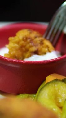 Abur cubur reklamı konsepti. Fast food teslimatı, kanepede oturup televizyon izlemek, arkadaşının tavuğunu elinde tutmak, koklamak ve ısırmak, tadını çıkarmak. Ağır çekim. Yüksek kalite 4k görüntü