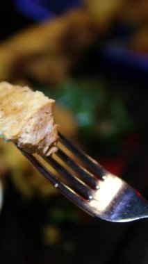 Abur cubur reklamı konsepti. Fast food teslimatı, kanepede oturup televizyon izlemek, arkadaşının tavuğunu elinde tutmak, koklamak ve ısırmak, tadını çıkarmak. Ağır çekim. Yüksek kalite 4k görüntü