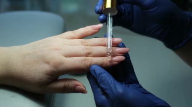 Dikkatli el bakımı: tırnak etlerini geriye itmek ve kırılgan tırnakları güçlendirmek için şifa cilası sürmek. Yüksek kalite 4k görüntü