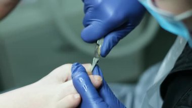 Adam düşük ışıkta, arka planda bronz tırnak makası kullanıyor. Yüksek kalite 4k görüntü