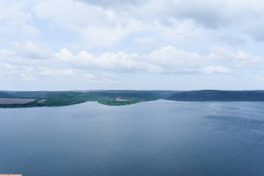 Fotoğraf Ukrayna 'nın nehir manzaralarını, yeşil tepeleri, mavi gökyüzünü gösteriyor.