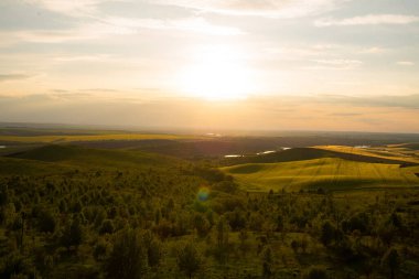 Yeşil tepelerin ve sonsuz vadilerin ardında inanılmaz bir gün batımı.