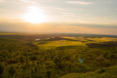 Yeşil tepelerin ve sonsuz vadilerin ardında inanılmaz bir gün batımı.