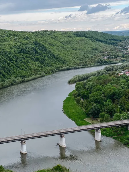 Fotoğraf, Ukrayna 'nın eşsiz, büyülü ve inanılmaz doğasını, yeşil manzaraları, tepeleri ve köprüsü olan nehri tasvir ediyor..