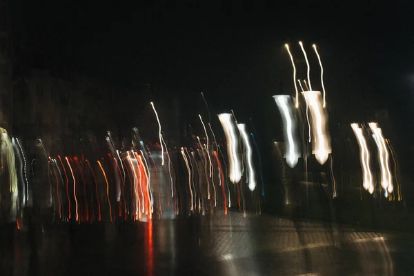 Fotoğraf parlak renk aksanlı, gece şehrinin parlak, soyut, bulanık ışıklarını gösteriyor.