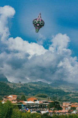 Mavi gökyüzü ile balon festivali ve arkada Tusa tepesi - Venedik, Antioquia, Kolombiya.